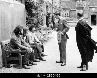 The Prince of Wales stops to talk with students seated n a bench in the Inner Quad during his visit to Jesus College, Oxford, where he opened the Old Members' Building to mark the 400th anniversary of the college. The new building cost about £130,000 and was financed by an appeal to old members of the college and fellows. Stock Photo