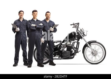 Full length portrait of a team of mechanics standing with a customized chopper motorbike isolated on white background Stock Photo