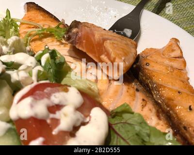 Salmão grelhado com salada de tomate e alface. Prato de restaurante brasileiro. Stock Photo