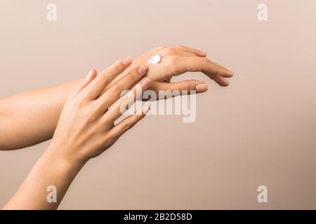skin care and protection. beautiful hands of a young woman with moisturizer on them Stock Photo