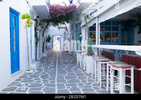 Cafe and restaurants at amazing narrow streets of popular destination on Paros island. Greece. Traditional architecture and colors of mediterranean ci Stock Photo