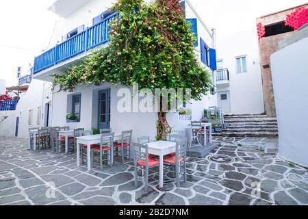 Cafe and restaurants at amazing narrow streets of popular destination on Paros island. Greece. Traditional architecture and colors of mediterranean ci Stock Photo