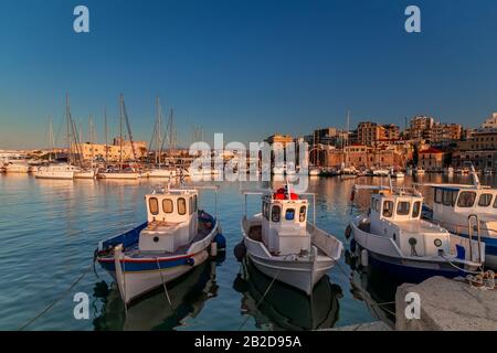 Panoramic view of beautiful sunset in Koules Fortress (Rocca a Mare), Crete island. Yachts reflecting in the mirror of water near Venetian old harbor Stock Photo