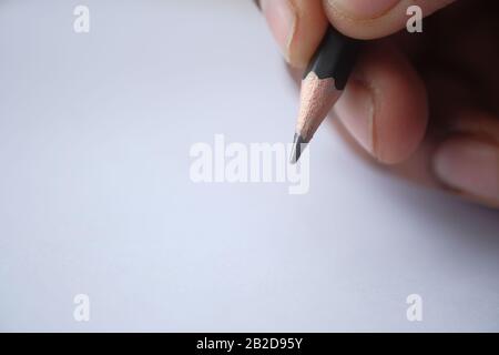 close of man hand writing with pencil on paper  Stock Photo