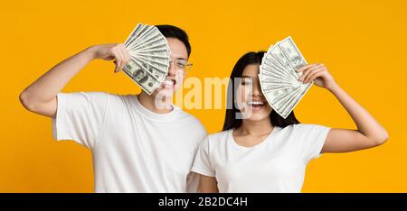 Rich asian couple holding bunch of money Stock Photo