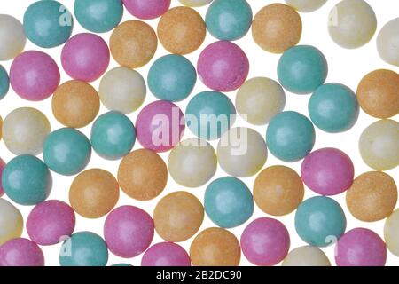 Pastel green, orange, pink and yellow sugar-coaged chocolate candy in the shape of oblate spheroid Stock Photo