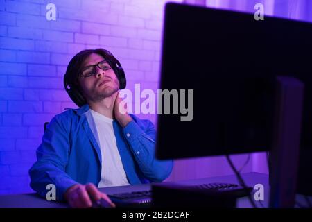 Tired Programmer Working On Computer Touching Aching Neck At Home Stock Photo
