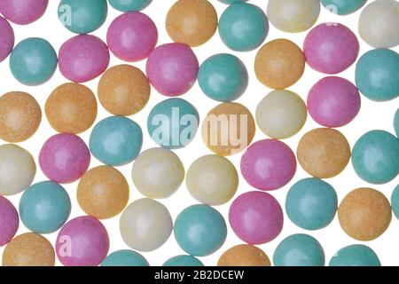 Pastel green, orange, pink and yellow sugar-coaged chocolate candy in the shape of oblate spheroid Stock Photo