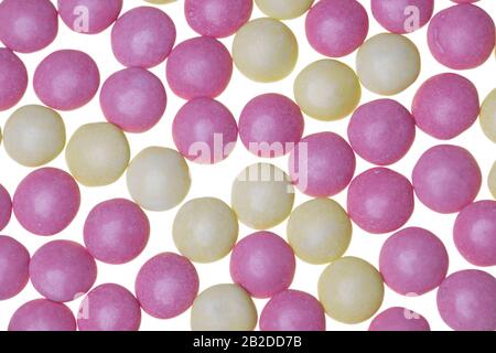 Pink and yellow sugar-coaged chocolate candy in the shape of oblate spheroid Stock Photo