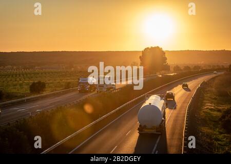 Tanker truck with dangerous goods circulating on the highway at sunset Stock Photo