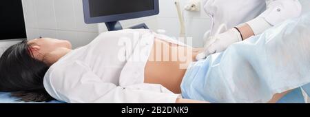 Gynecologist doing ultrasound scanning for pregnant woman Stock Photo