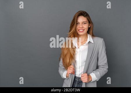 Young business woman studio isolated on gray laughing cheerful Stock Photo