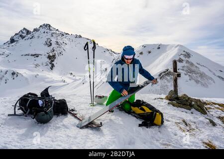 Ski tourers bouncing at the summit, on the right Moelser Sonnenspitze, behind snow-covered mountains, Wattentaler Lizum, Tuxer Alps, Tyrol, Austria Stock Photo