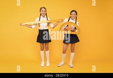 Explore world with math. Discover mathematics patterns. Mathematical theory combining algebraic and geometric methods. School students study geometry. Pupil school girls big rulers. School knowledge. Stock Photo