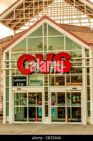 Charlotte, NC/USA - December 14, 2019: Medium vertical closeup of 'CVS Pharmacy' brand in bold bright red letters mounted on glass and steel facade en Stock Photo