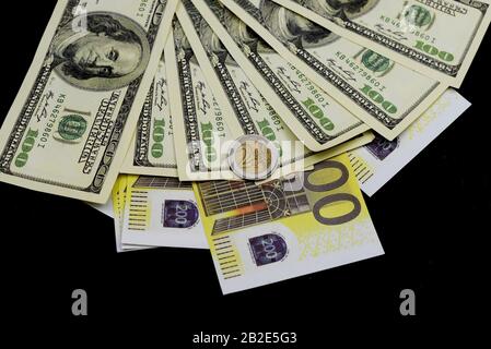 euro coin with dollars notes and banknotes on a black background for business and finance Stock Photo