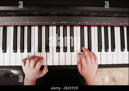 top view of hands playing on a synthesizer with white and black keys with musical term Stock Photo