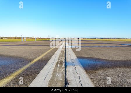 Cracking asphalt road, airport runway or airfield at Tempelhof Field park, former airport, in Berlin, Germany. Stock Photo