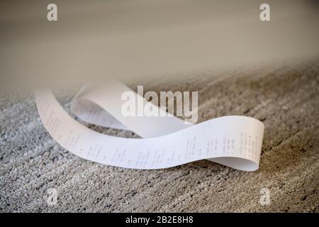 Adding Machine paper tape gathered on carpeted floor Stock Photo