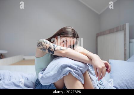 woman sitting on bed arms outstretched