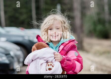 candid portrait of a young girl smiling  with messy hair and comforter