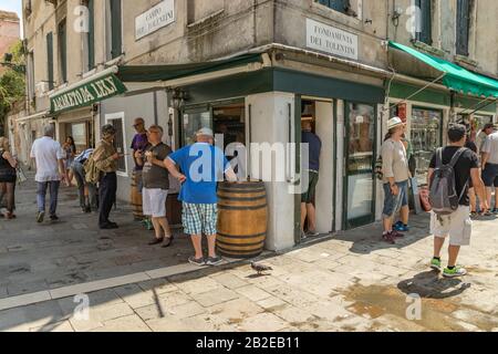 VENICE, ITALY - August 02, 2019: View from bridge in Venice. Locals and tourists strolling along the narrow Venetian pedestrian streets with historica Stock Photo