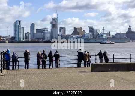 Spectators gathering at Seacombe on the Wirral to watch HMS Prince of Wales aircraft carrier across the Mersey at Liverpool docks Stock Photo