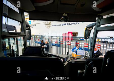 Tour guides wait for tourist cruise ship passengers at the bus pickup area along the cruise port at Copenhagen Denmark. Stock Photo
