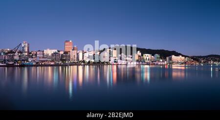 Wellington, New Zealand city buildings and skyline reflected in the harbour at sunrise on a perfect summer morning. Wellington is the capital of NZ. Stock Photo