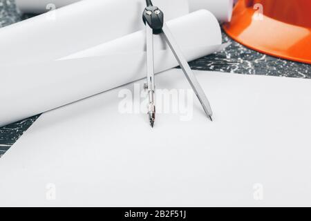 Engineer workplace with blueprints, compass, pencil and safety helmet. creative photo. Stock Photo