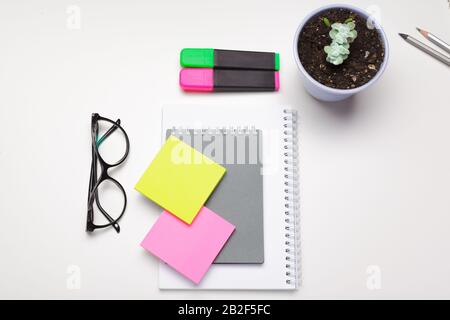 Sticky notes with markers, colored pens, paper clips laying on a table Stock Photo