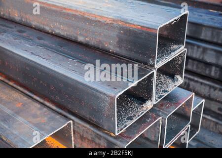 Stacked rolled metal products, wet steel pipes of rectangular cross-section Stock Photo