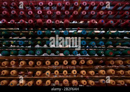 Rows of thread on spools are ready to supply a weaving loom. At the National Wool Museum in Geelong, Victoria, Australia. Stock Photo