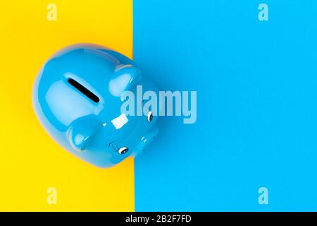 Blue piggy bank money box on bright colored background Stock Photo