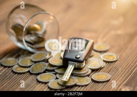 Close up new car keys pile of coin on wooden table. Car financial, Car purchase, or car rental concept Stock Photo
