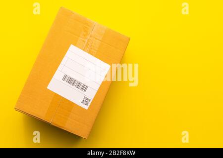 Top view empty brown post or carton box on yellow paper background. Online order and delivery concept Stock Photo