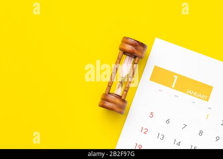 Close up vintage hourglass or sandglass on new year calendar for planning concept Stock Photo