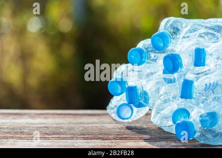 Heap of empty clear plastic water bottle on wooden plank. Close up composition. Recycle concept Stock Photo