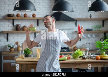 Man in an apron standing with his eyes closed. Stock Photo