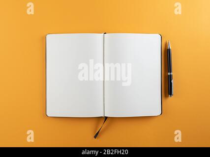 open diary or notebook with blank white pages on orange background template Stock Photo