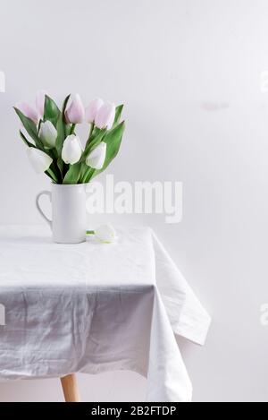 Bunch ofwhite and pink tulips in a white vase on white table Stock Photo