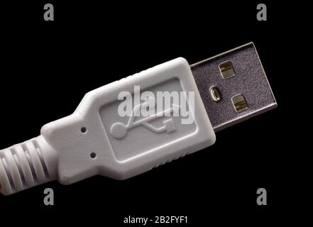 USB plug on a white cable with logo. Standard type A male connector isolated on black. Stock Photo