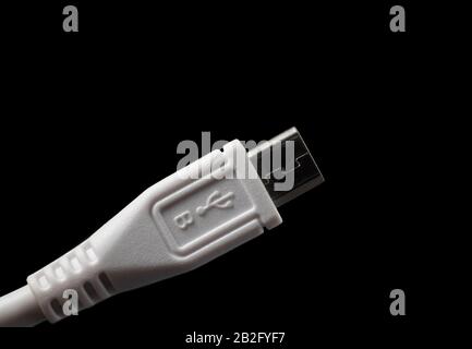Micro USB type B plug with logo. Male connector isolated on black. Stock Photo
