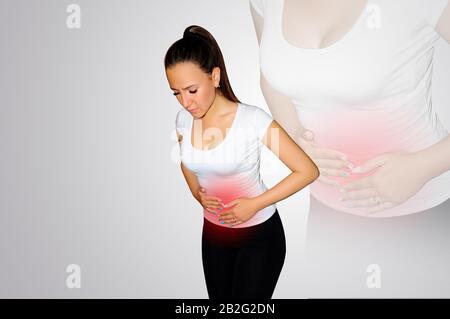 Abdominal pain. A young woman suffers from pain in the abdomen. The problem with digestion. The problem of women's health, the concept of menstruation Stock Photo