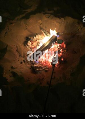 toasting marshmallows over campfire in the desert Stock Photo
