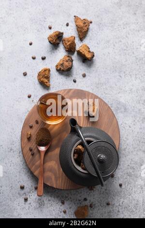 Chaga mushroom slicing and preparation for making healthy drink in teapot. Trendy healthy birch mushrooms. View from above. Flat lay. Stock Photo