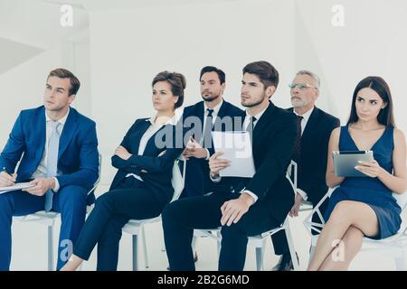 Confident young managers making notes during lecture Stock Photo