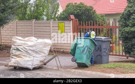Alberton, South Africa - unidentified persons search in household garbage bins on a misty autumn morning for reusable and recyclable items Stock Photo