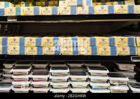 packs, blocks, bricks of butter on a shelf in an open fridge in a supermarket, store, shop in South Africa Stock Photo