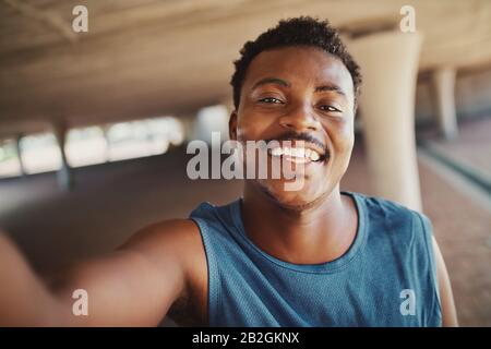 Portrait of a smiling young african american man taking selfie after jogging at outdoors Stock Photo